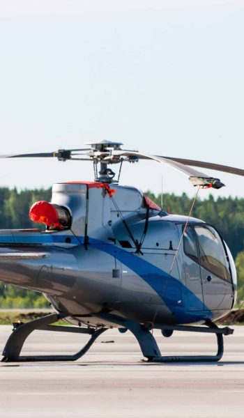 Single engine light helicopter on the airport apron